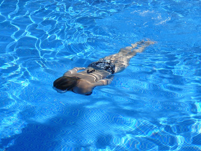 Can an existing pool be modified? - Woman with goggles swimming underneath water in a pool