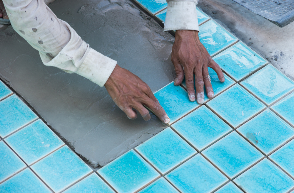 Pool refinishing contractor laying tiles