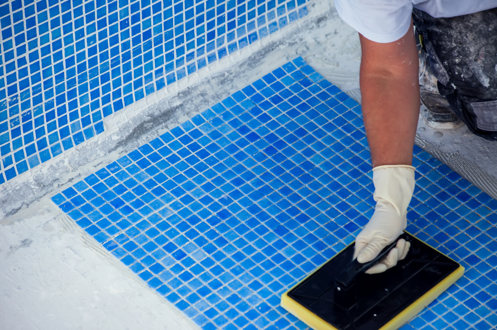 Pool tile repair - contractor installing new pool tiles